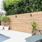 Teak slatted fence with horizontal 50 mm slats on a patio