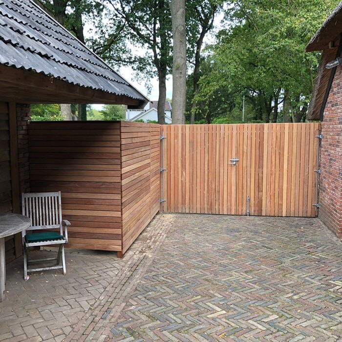 Wooden double gate with matching side panel in a fence