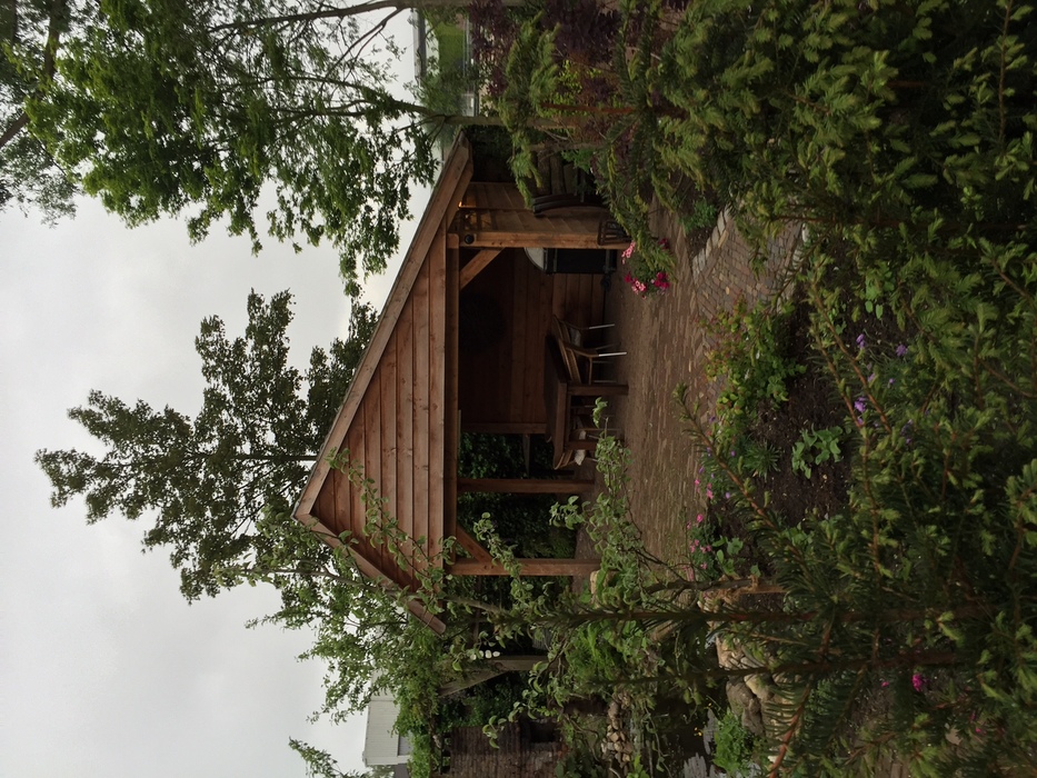 Classic Douglas fir cart shed with an asymmetric roof in a rustic garden