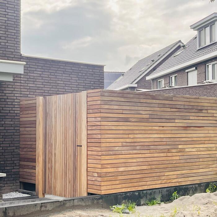 Modern fencing made of 9.0 cm Ipe slats featuring a matching gate and heavy-duty posts.