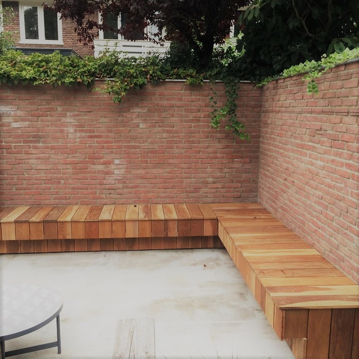 Luxury Ipé hardwood corner bench mounted along a stone garden wall