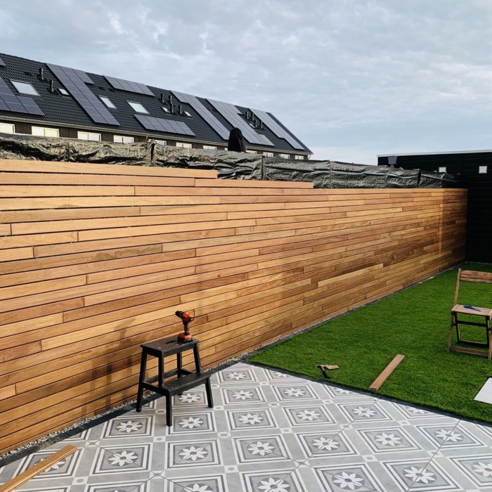 Luxury wooden slatted fence made of 7 cm Ipé slats installed with invisible mounting clips.
